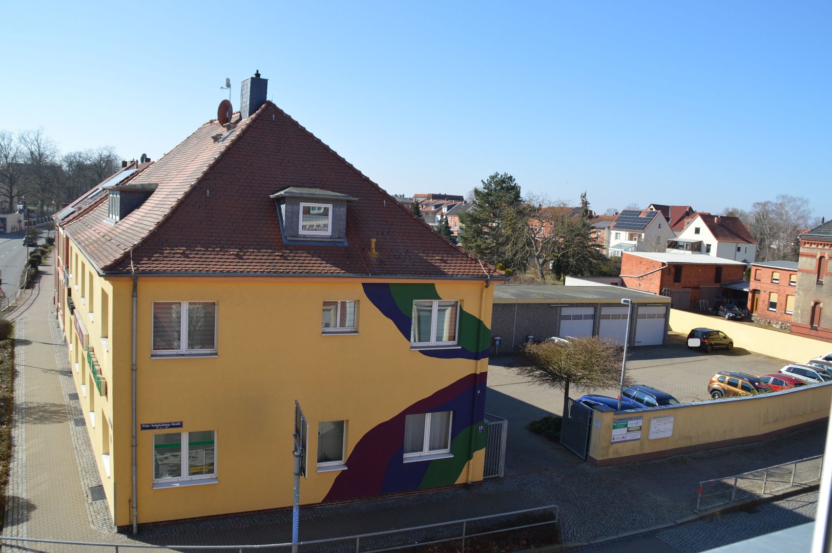 Gesamtansicht Wohn- und Geschäftshaus mit Garagen und Stellplätzen